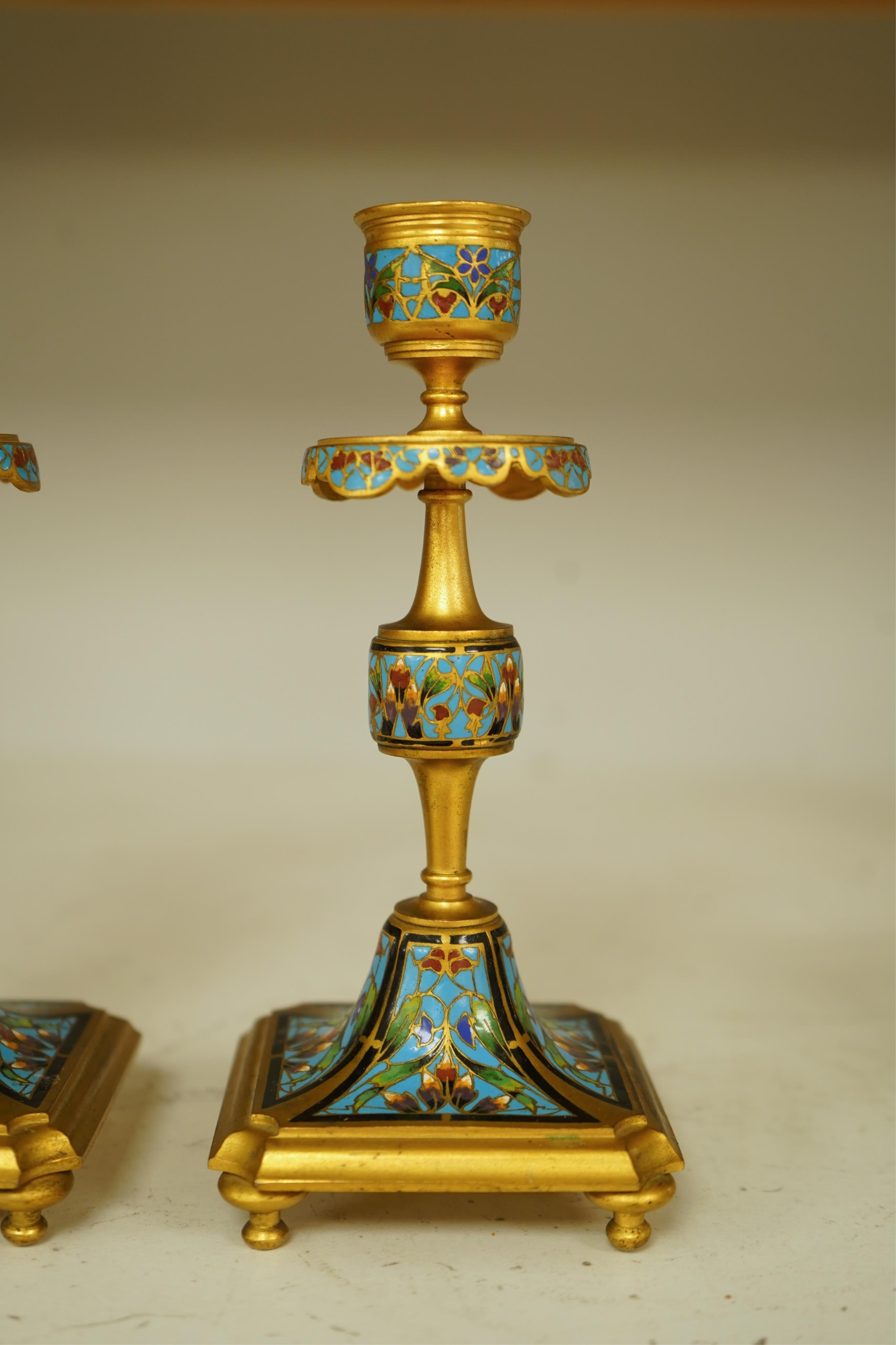 A pair of late 19th century French champleve enamel and ormolu candlesticks, 17cm